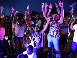Protesters with hands in the air gesture...